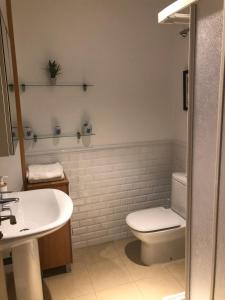a bathroom with a white toilet and a sink at La plaza de llanes, Plaza Parres Sobrino, 6 in Llanes +43 photos