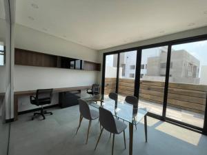 una sala da pranzo con tavolo e sedie in vetro di Mono ambiente en Equipetrol - Edificio La Foret a Santa Cruz de la Sierra