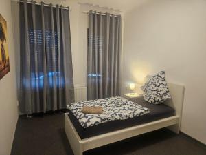 a small bedroom with a bed and curtains at Work and Stay Eschweiler 50qm 2 Betten Küche und Badezimmer in Eschweiler +10 photos
