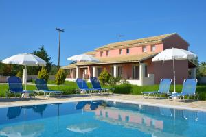 a group of chairs and umbrellas next to a pool at Megali Luxuries Apartments in Sidari