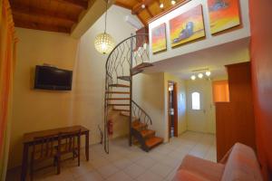 a living room with a spiral staircase and a tv at Megali Luxuries Apartments in Sidari