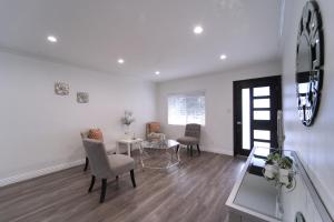 a living room with chairs and a table and a mirror at Modern LA Home - King Bed, Outdoor Living, Firepit in Los Angeles