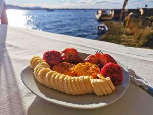 a plate of fruit on a table next to the water at Lake View Lodge in Puno