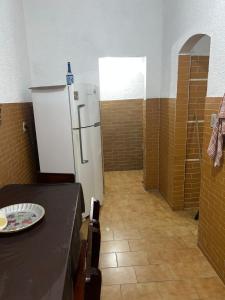 a kitchen with a refrigerator and a table in a room at Casa de Muriqui in Mangaratiba