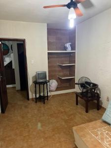a living room with a ceiling fan and a tv at Casa de Muriqui in Mangaratiba
