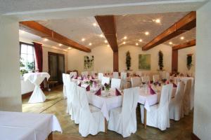 einen Bankettsaal mit weißen Tischen und weißen Stühlen in der Unterkunft Landhotel Bergischer Hof GmbH Marialinden in Overath