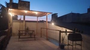 a pergola on a rooftop with a table and a bench at Terraza del Rio in Formosa