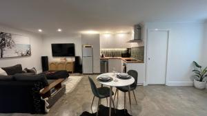 a living room with a couch and a table with chairs at Avalon Beach Guesthouse in Whale Beach