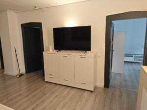 a living room with a flat screen tv on a white cabinet at Work and Stay 6 Zimmer 150qm 12 Betten 3 Badezimmer in Meinerzhagen