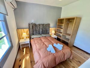 a bedroom with a large bed with two blue towels at Apartamento Je Nous - José Ignacio in José Ignacio