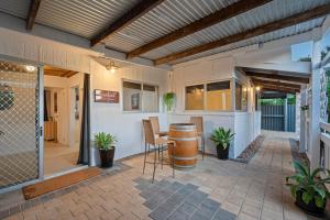 a patio with a bar with chairs and a table at Driftwood Beach House - A Cosy Coastal Cottage in Aldinga Beach