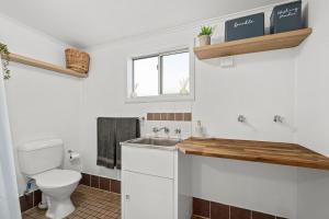 a bathroom with a toilet and a sink at Driftwood Beach House - A Cosy Coastal Cottage in Aldinga Beach