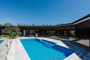 an image of a swimming pool in front of a building at The Wine Manor - Lavish Poolside Living in Mudgee