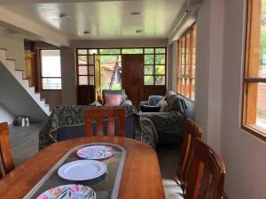a living room with a wooden table and chairs at La casa del bosque CALCA in Pisac +11 photos