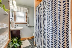a bathroom with a shower curtain and a sink at Secluded Home with Lake View in Delton! in Delton