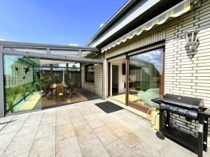 un patio con puertas correderas de cristal y una parrilla en 150m² Apartment nahe A1 - 5 Schlafzimmern - 3 Bäder - 50m² Terrasse, en Siek