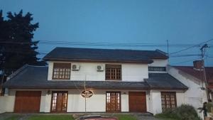 a white house with a black roof at Casa Alvear - Bed & Breakfast in Tandil