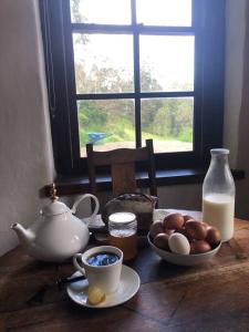 Cob Cabin - Sacred Earth Farm في Pumpenbill: طاولة عليها وعاء من البيض وإبريق من الحليب +23 صورة