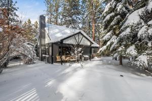 une maison dans les bois avec de la neige au sol dans l'établissement Pinecone Escape - Close to Lake and Slopes, à Big Bear City