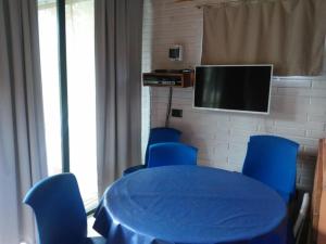 a room with a blue table and chairs and a tv at Casitas del Lago in Potrero de Garay