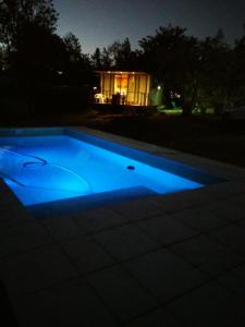 a swimming pool at night with a house in the background at Casitas del Lago in Potrero de Garay