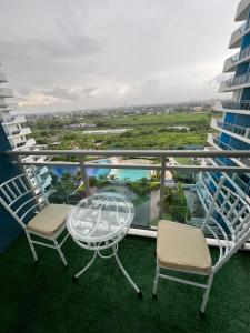 a balcony with a glass table and chairs on a building at Azure North Amirah’s Place in San Fernando