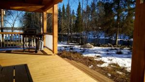 una veranda riparata con griglia su un cortile coperto da neve di Koskikara Cottage a Kymönkoski