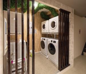 een wasruimte met twee wasmachines en twee magnetrons bij OASIS NANIWA in Osaka