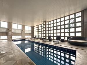 a large swimming pool with a tub and a sink at Suíte Pátio Paulista 1309 in São Paulo