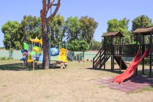 a park with a playground with slides and a tree at Villa in Cecina Mare near Sandy Beaches in Marina di Cecina