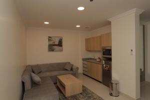 a living room with a couch and a kitchen at فيوبارك 2للشقق المخدومة درجةاقتصادية in Al Ahsa