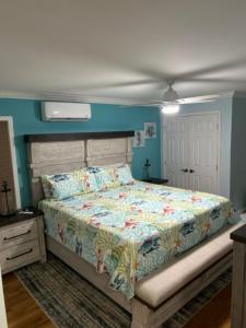 a bedroom with a bed and a blue wall at Playing Hookie LLC in Dauphin Island