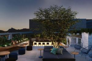 a rooftop patio with a tree and tables and chairs at Studio 309 Luxo no coração do Rio - piscina, academia, sala de reunião in Rio de Janeiro