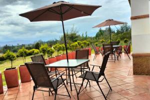 a table and chairs with an umbrella on a patio at Rafaella in Villa de Leyva