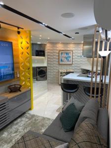a living room with a couch and a kitchen at Apartamento de luxo na Beira Mar in Fortaleza