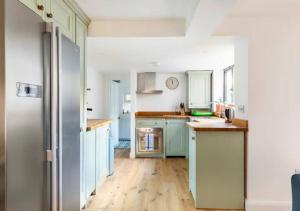 cocina con armarios azules y suelo de madera en Stanley Road - Gorgeous Modern Flat in Oxford!, en Oxford 26 fotos más
