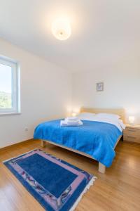 Un dormitorio con una cama azul y una alfombra azul. en Family-friendly apartments with swimming pool Milna, Brac - 22122, en Milna 35 fotos más