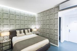 una camera con un grande letto e una parete di cemento di Residenza Monfy a Roma
