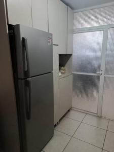 a kitchen with a stainless steel refrigerator in a room at Casa dentro de Coto Parques de Tesistan in Tesistán