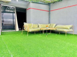 Un sofá y una mesa en un césped verde en Laetitia Belle Vue, en Abiyán