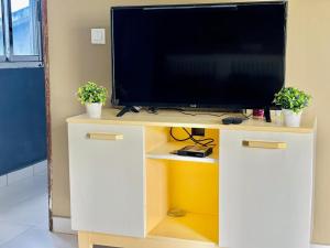 un televisor en la parte superior de un centro de entretenimiento blanco en Laetitia Belle Vue, en Abiyán