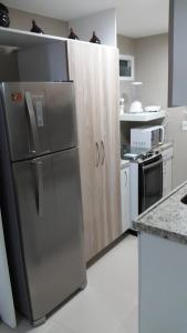 uma cozinha com um frigorífico de aço inoxidável e um balcão em VG Fun Residence - Fortaleza Flats em Fortaleza