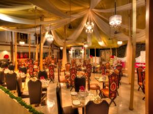 a restaurant with tables and chairs and chandeliers at Estrela Do Mar Beach Resort - A Beach Property in Calangute