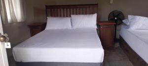 a bedroom with two beds with white sheets and pillows at Oribi Farm Stay in Port Shepstone