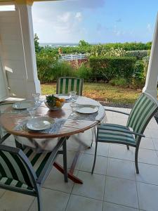 a table and two chairs on a porch at Blue Side in Le Moule +8 photos