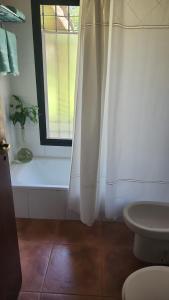 a bathroom with a window and a white shower curtain at Aire de campo en la ciudad in San Fernando del Valle de Catamarca +25 photos