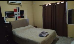 a bedroom with a bed and a dresser and a window at Alojamiento temporario Bordon in San Salvador