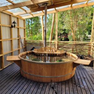 an outdoor hot tub on a deck with a pergola at Cabañas Costa Aituy in Queilén