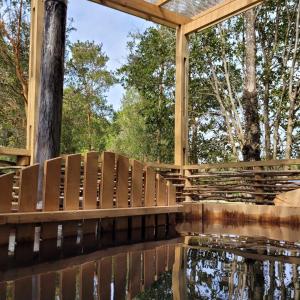 a wooden bridge over a body of water at Cabañas Costa Aituy in Queilén