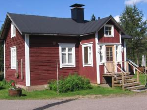 una casa rossa e bianca con tetto nero di Myllyn Pirtti Cottage a Naamijoki